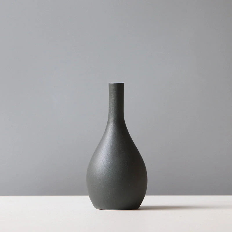 Stylish ceramic vases in various colors, including brown, black, green, and orange, for modern home decor