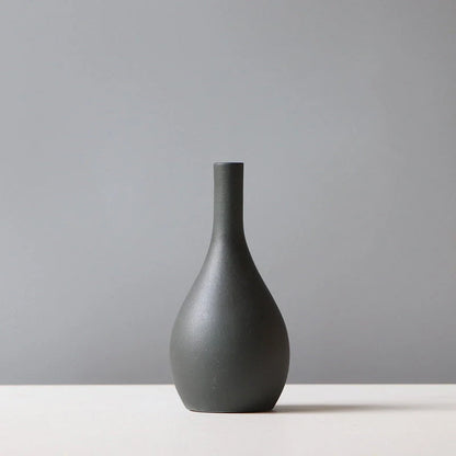 Stylish ceramic vases in various colors, including brown, black, green, and orange, for modern home decor