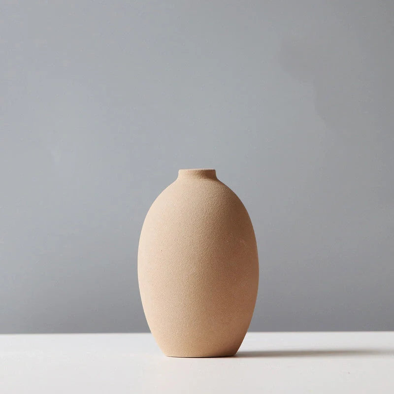 Stylish ceramic vases in various colors, including brown, black, green, and orange, for modern home decor