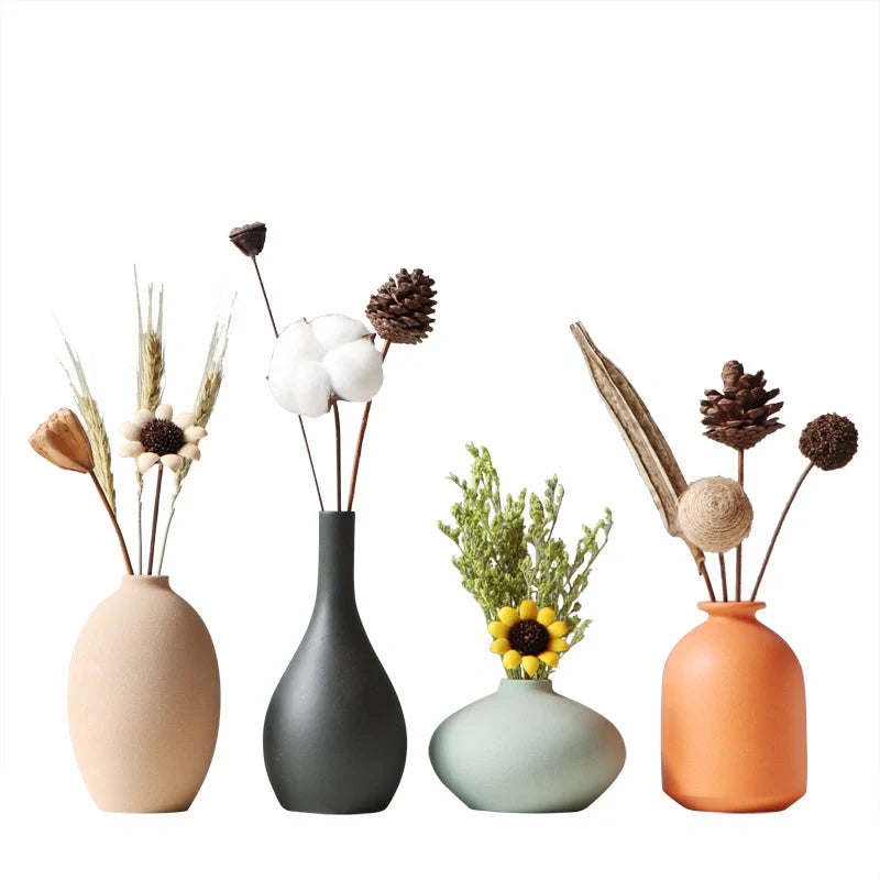 Stylish ceramic vases in various colors, including brown, black, green, and orange, for modern home decor
