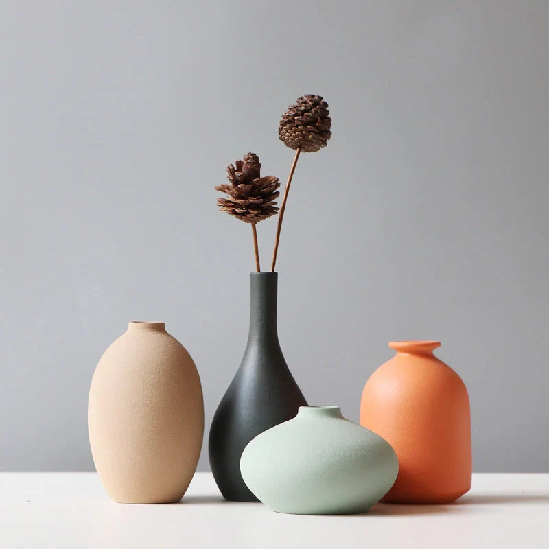 Stylish ceramic vases in various colors, including brown, black, green, and orange, for modern home decor