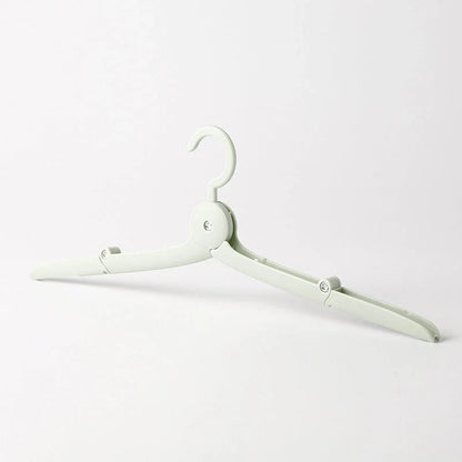 Compact folding hanger in blue, green, and pink colors, showing telescopic design for travel and dorm use