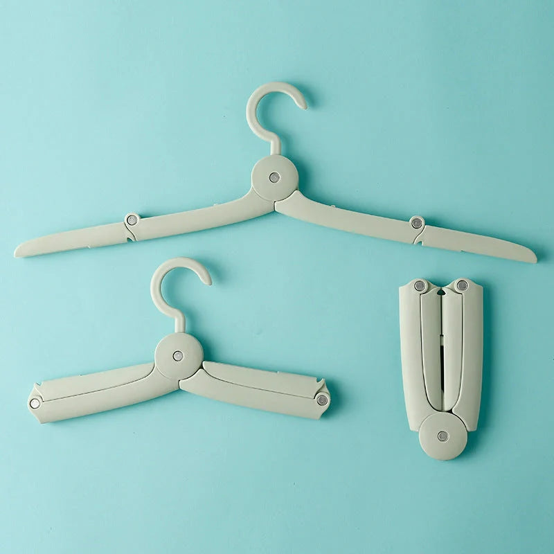 Compact folding hanger in blue, green, and pink colors, showing telescopic design for travel and dorm use