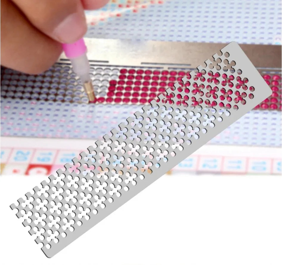 Stainless steel diamond painting grid ruler for round and square drills on a craft table.
