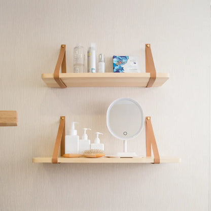 Natural pine wood wall mounted shelf with books and small items organised on it.