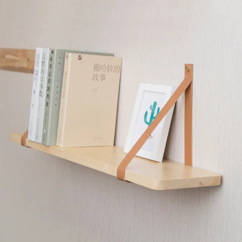 Natural pine wood wall mounted shelf with books and small items organised on it.