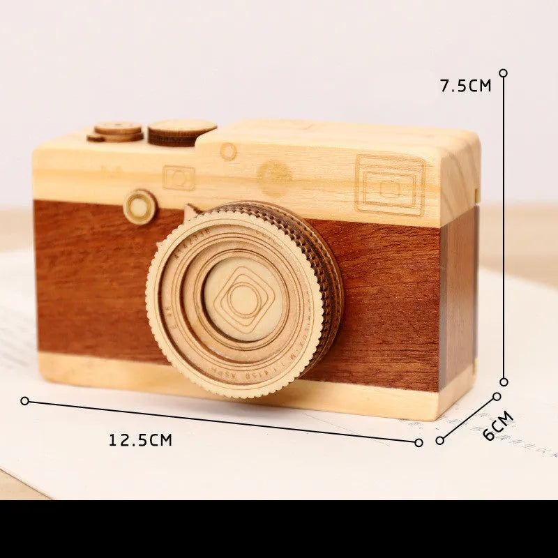 Wooden camera-themed rotating music box in sanding box packaging