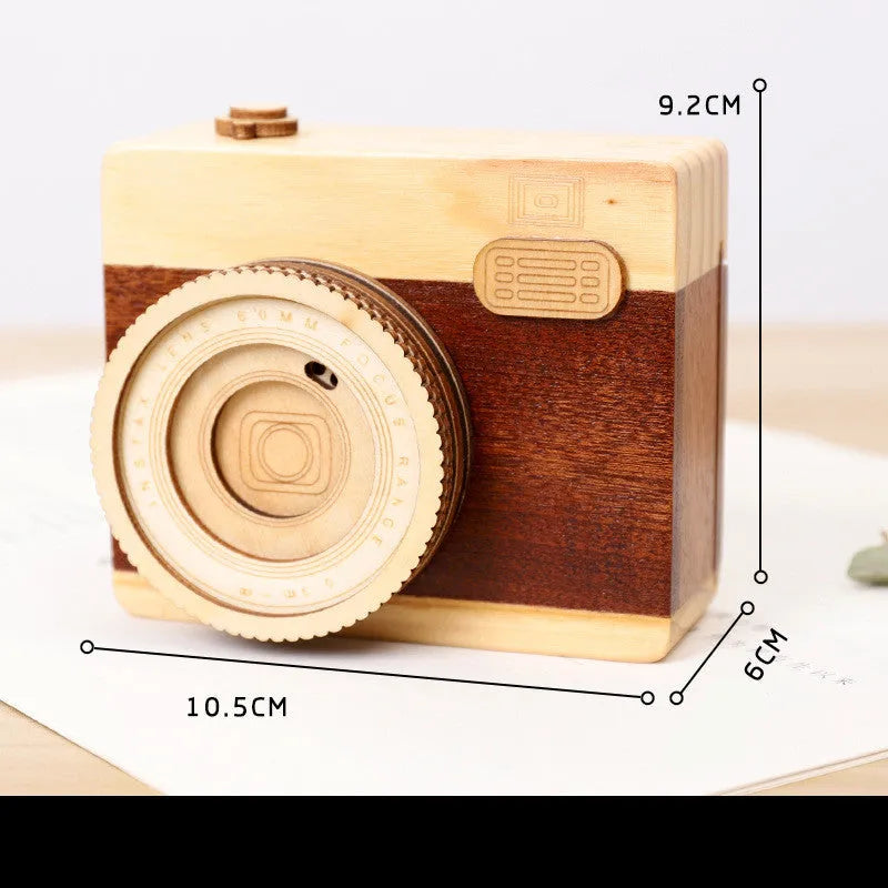 Wooden camera-themed rotating music box in sanding box packaging