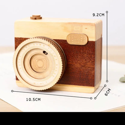 Wooden camera-themed rotating music box in sanding box packaging