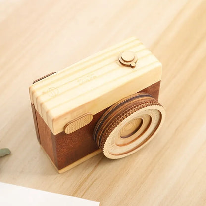 Wooden camera-themed rotating music box in sanding box packaging