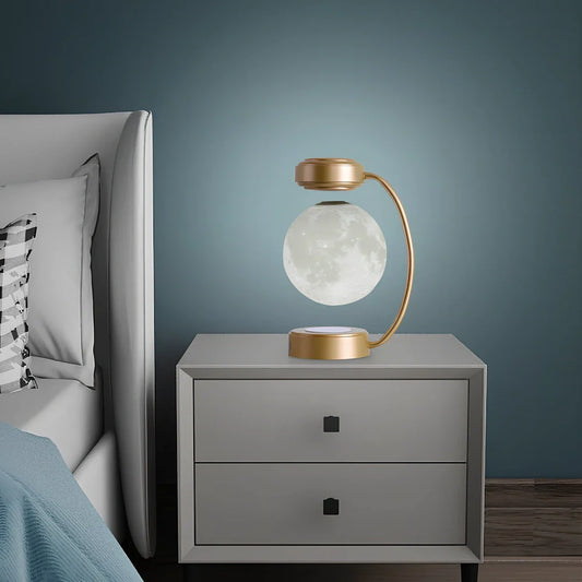 Black magnetic levitation moon lamp floating above base with golden illumination, showing touch control area
