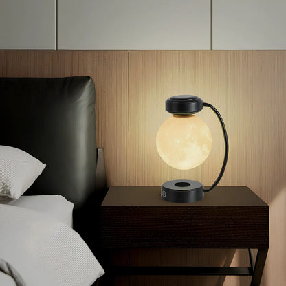 Black magnetic levitation moon lamp floating above base with golden illumination, showing touch control area