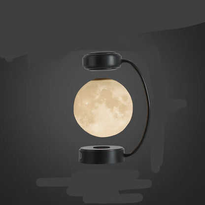 Black magnetic levitation moon lamp floating above base with golden illumination, showing touch control area