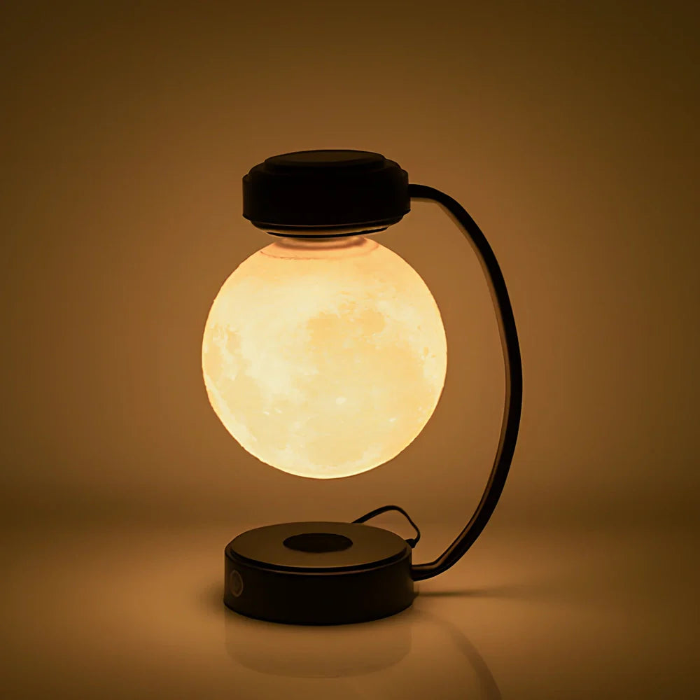 Black magnetic levitation moon lamp floating above base with golden illumination, showing touch control area