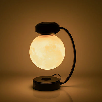 Black magnetic levitation moon lamp floating above base with golden illumination, showing touch control area