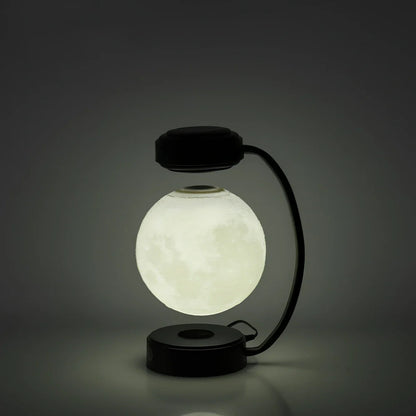 Black magnetic levitation moon lamp floating above base with golden illumination, showing touch control area