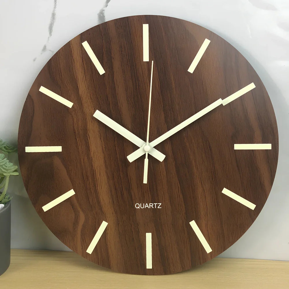 Round wood grain luminous wall clock with glowing numbers in dark room setting