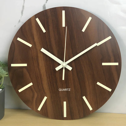 Round wood grain luminous wall clock with glowing numbers in dark room setting