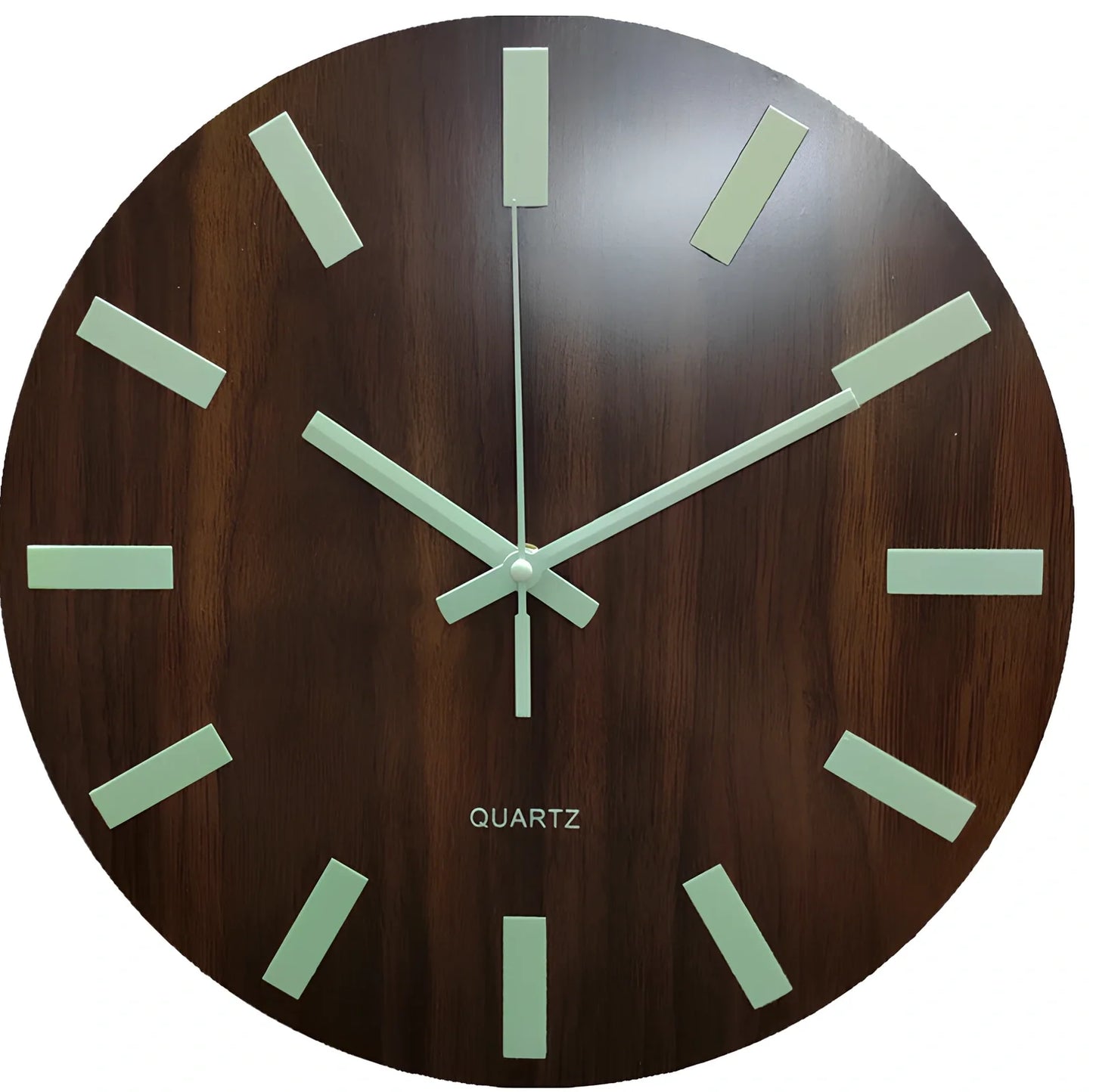 Round wood grain luminous wall clock with glowing numbers in dark room setting