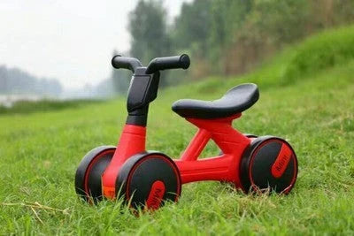 A stylish no-pedal balance bike with three wheels, vibrant colors, and optional light-up and music features for kids