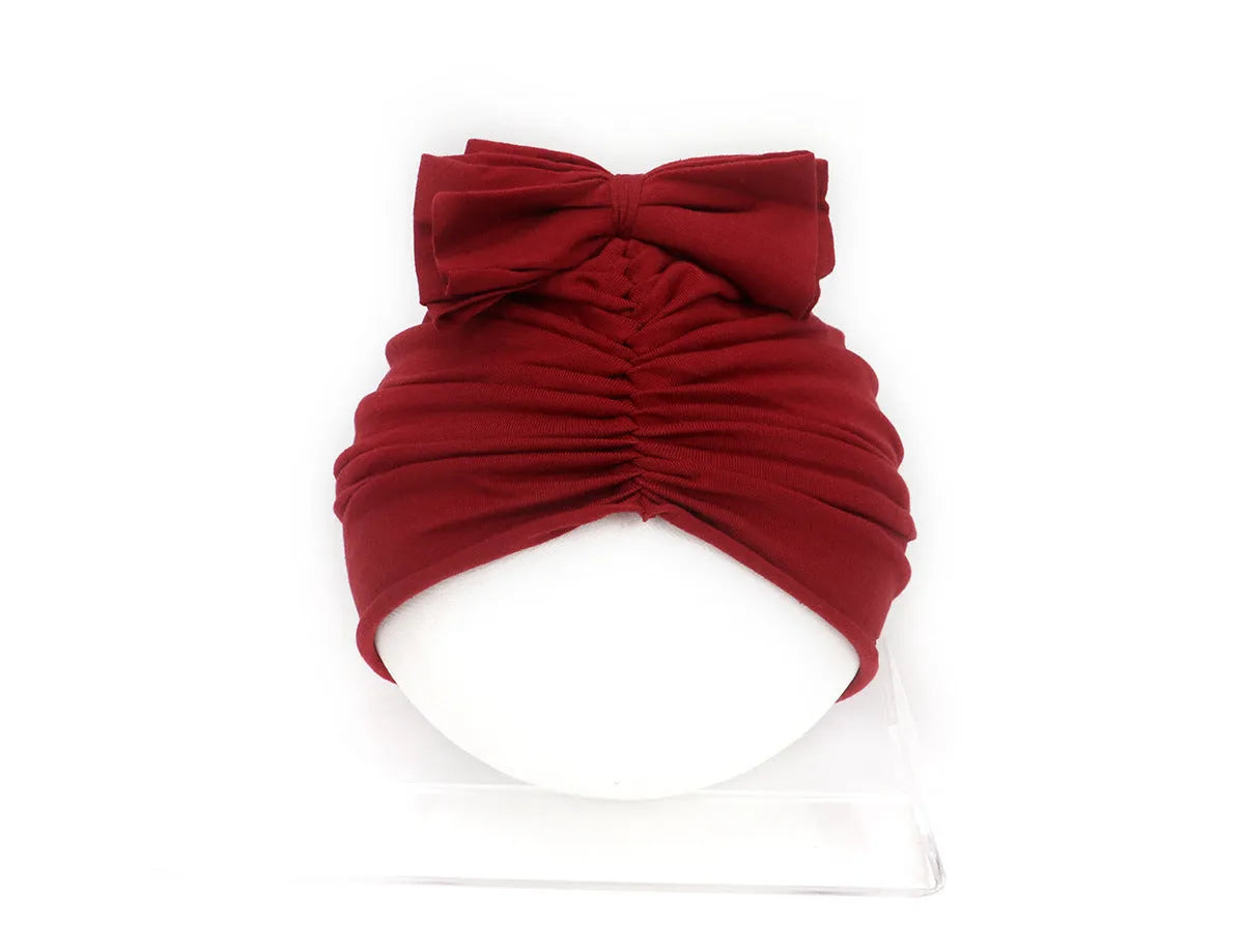 Soft acrylic knitted baby cap for newborns and toddlers in a solid colour, showing stretch fit.
