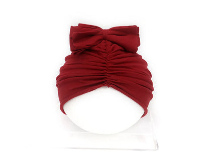 Soft acrylic knitted baby cap for newborns and toddlers in a solid colour, showing stretch fit.