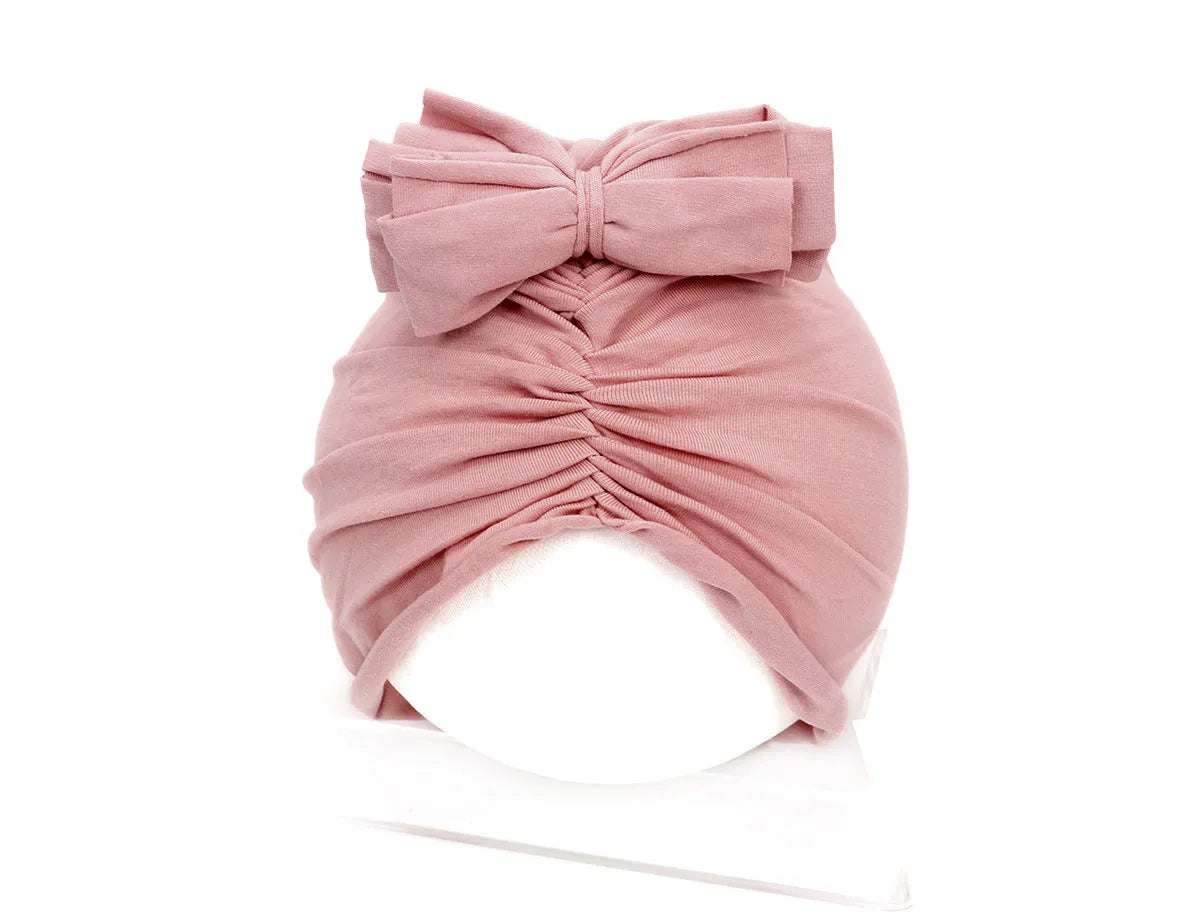 Soft acrylic knitted baby cap for newborns and toddlers in a solid colour, showing stretch fit.