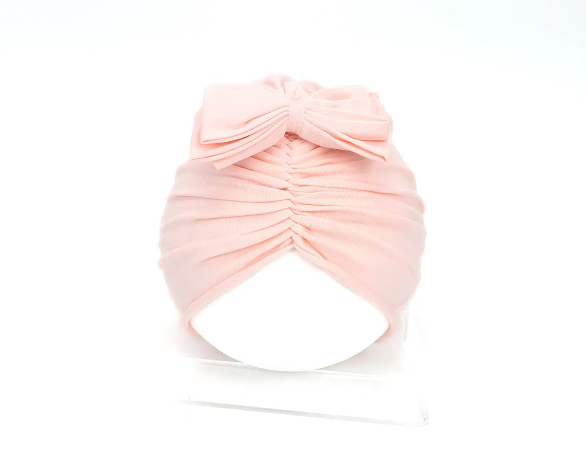 Soft acrylic knitted baby cap for newborns and toddlers in a solid colour, showing stretch fit.