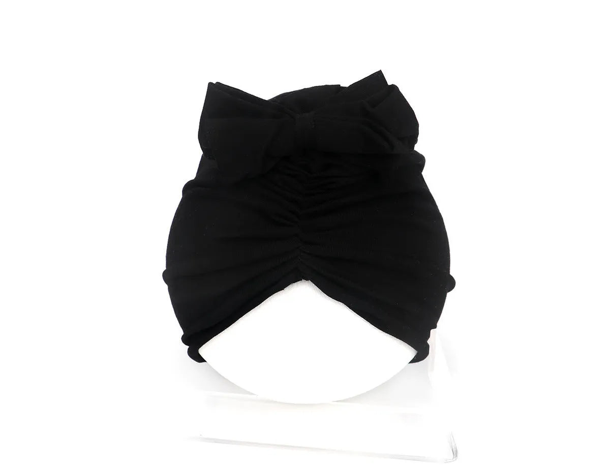 Soft acrylic knitted baby cap for newborns and toddlers in a solid colour, showing stretch fit.