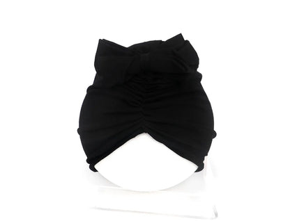 Soft acrylic knitted baby cap for newborns and toddlers in a solid colour, showing stretch fit.