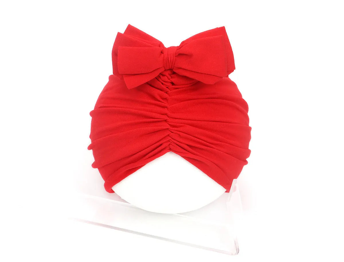 Soft acrylic knitted baby cap for newborns and toddlers in a solid colour, showing stretch fit.