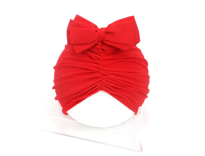Soft acrylic knitted baby cap for newborns and toddlers in a solid colour, showing stretch fit.