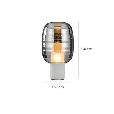 Transparent glass table lamp with modern Nordic design in cognac colour on wooden surface