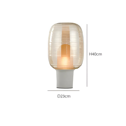 Transparent glass table lamp with modern Nordic design in cognac colour on wooden surface