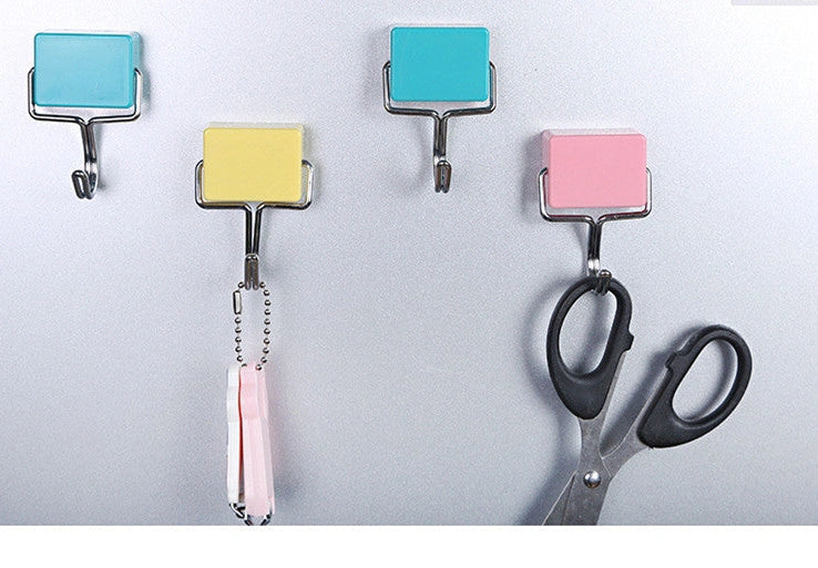 Yellow magnetic plastic hook with 4cm diameter base on metal surface holding kitchen utensils