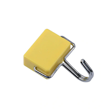 Yellow magnetic plastic hook with 4cm diameter base on metal surface holding kitchen utensils
