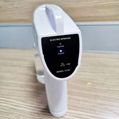 White cordless handheld electric spray gun with bottle, showing mist spray and USB Type-C charging port.