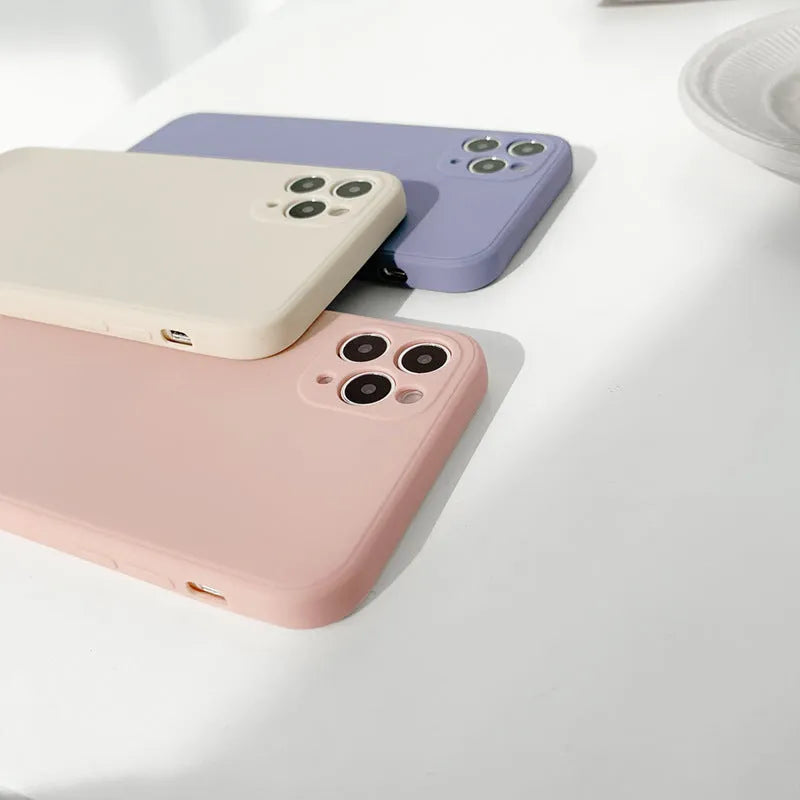 Simple solid colour silicone iPhone case in blue, pink, and white showing TPU back cover design.