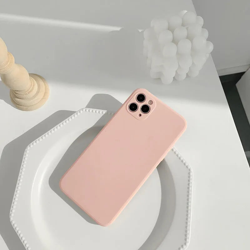 Simple solid colour silicone iPhone case in blue, pink, and white showing TPU back cover design.