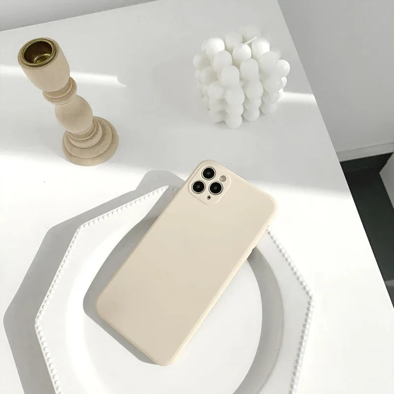 Simple solid colour silicone iPhone case in blue, pink, and white showing TPU back cover design.