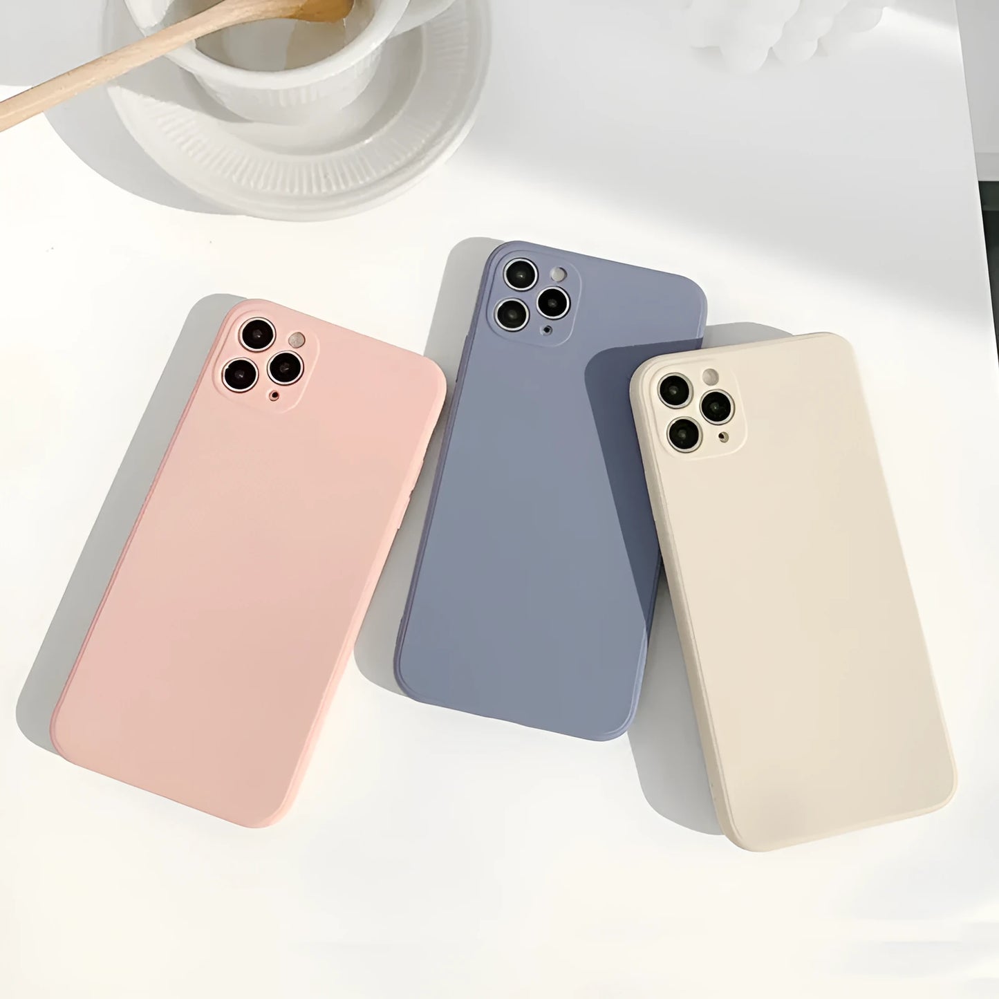 Simple solid colour silicone iPhone case in blue, pink, and white showing TPU back cover design.