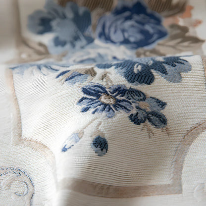 White chenille table runner with long tassels on wooden dining table