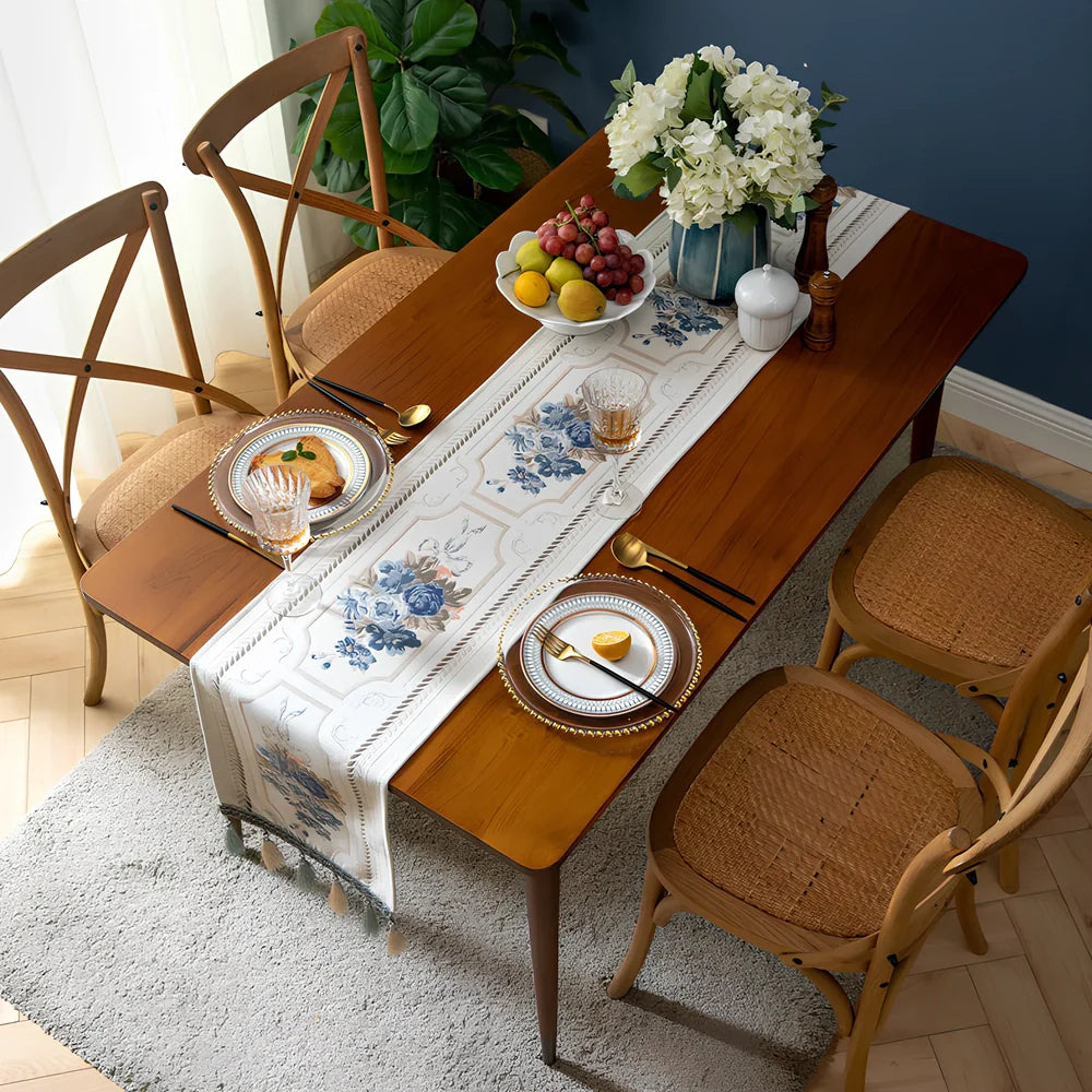 White chenille table runner with long tassels on wooden dining table