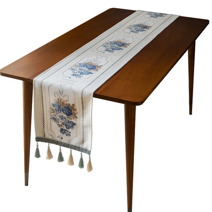 White chenille table runner with long tassels on wooden dining table
