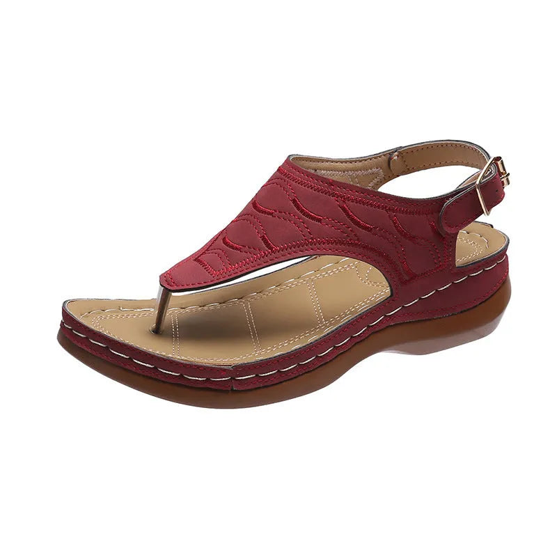 Women's wedge heel flip flop sandals in black with adjustable back strap on a light background