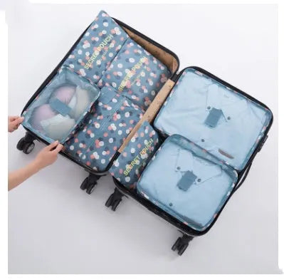 Set of six coloured nylon packing cubes and flat pouches for travel organisation.