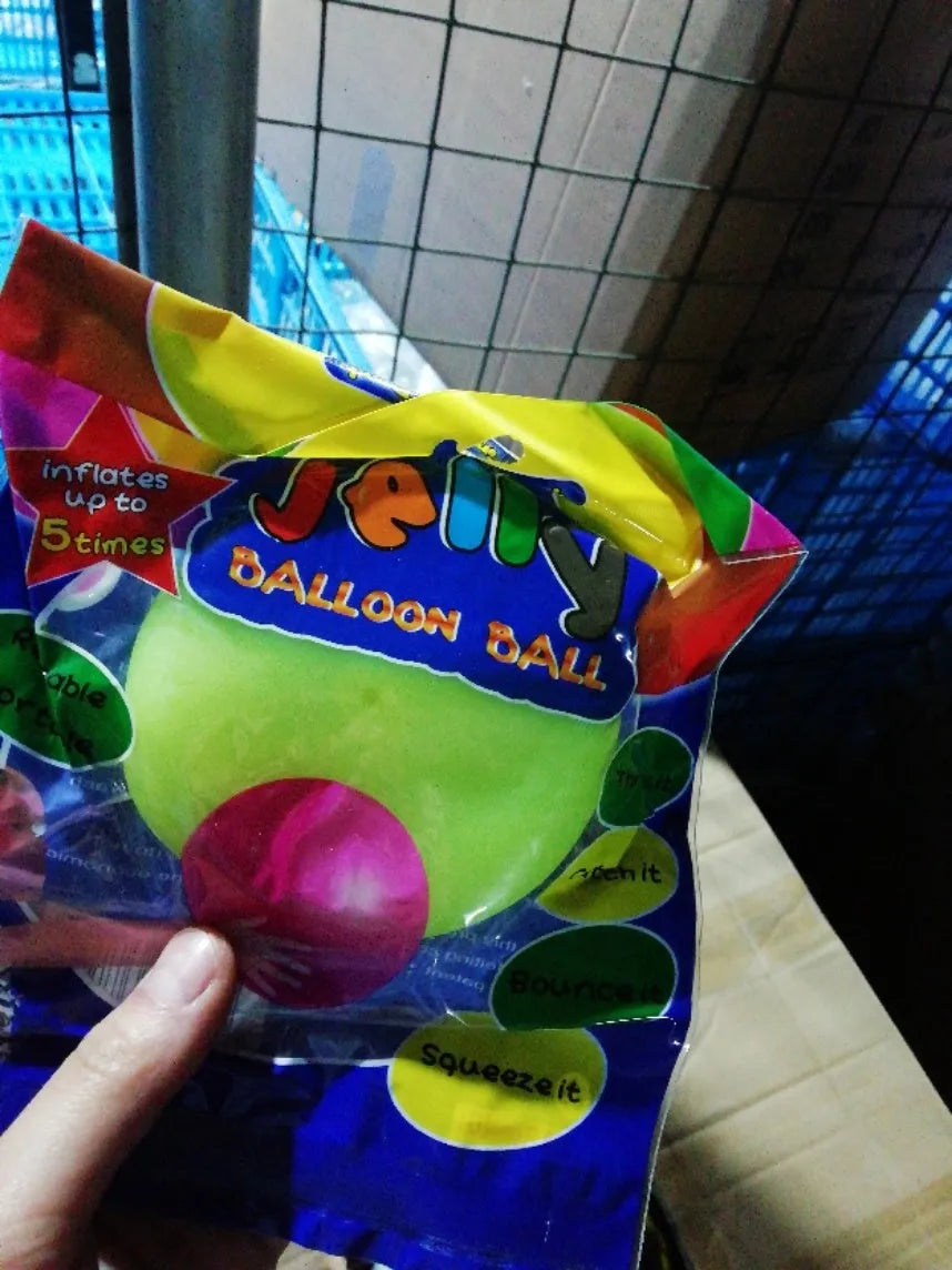 Large pink, yellow, green, and blue inflatable bouncy balls in various sizes for children's play.