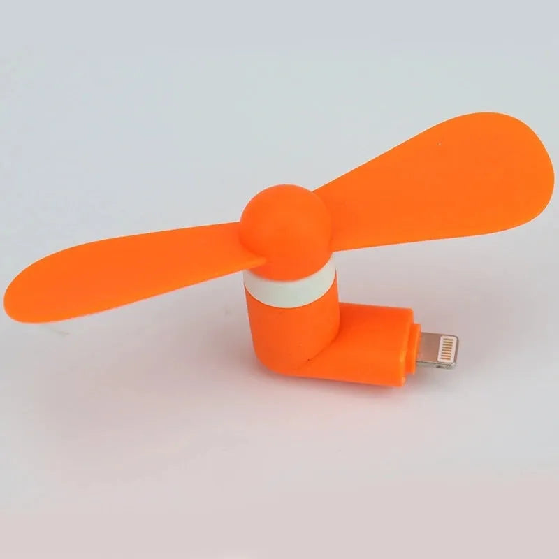 White portable mobile phone mini fan with plastic blades attached to smartphone