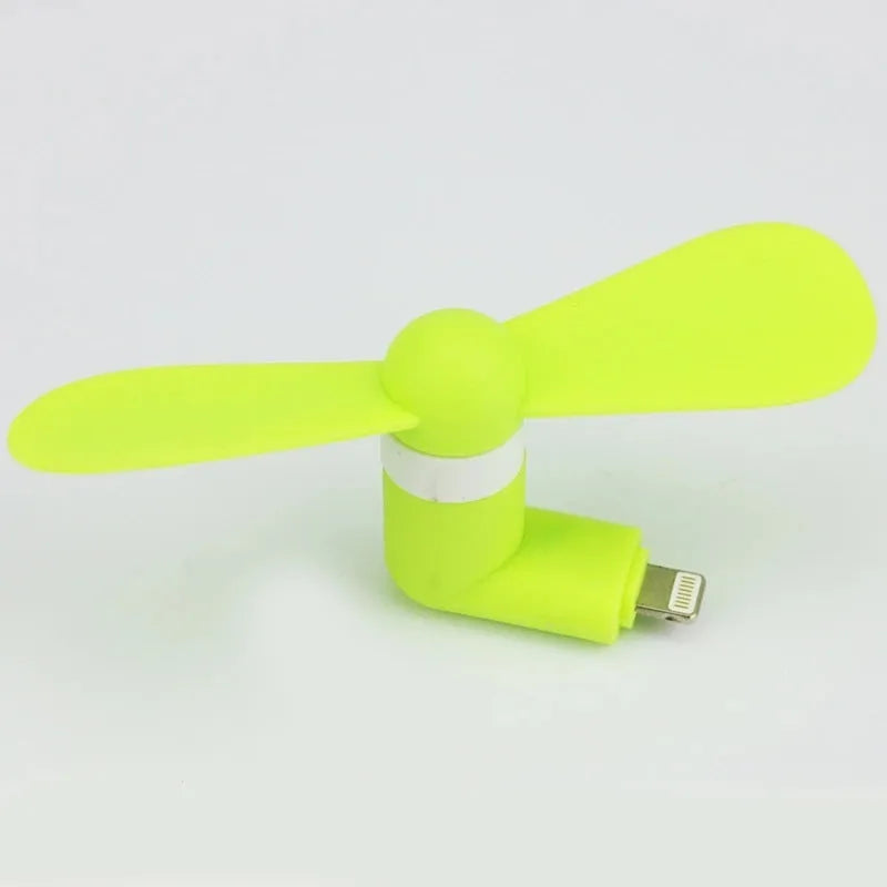 White portable mobile phone mini fan with plastic blades attached to smartphone