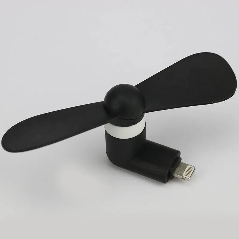 White portable mobile phone mini fan with plastic blades attached to smartphone